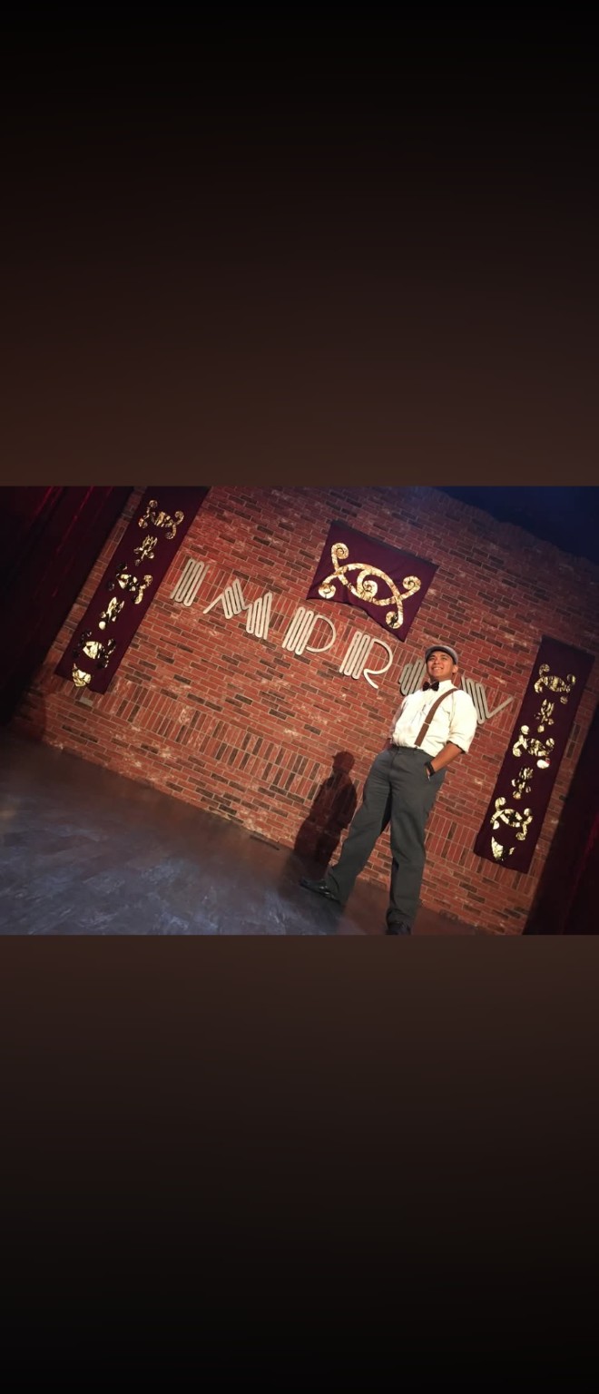 Tetra standing on a stage beneath an illuminated sign