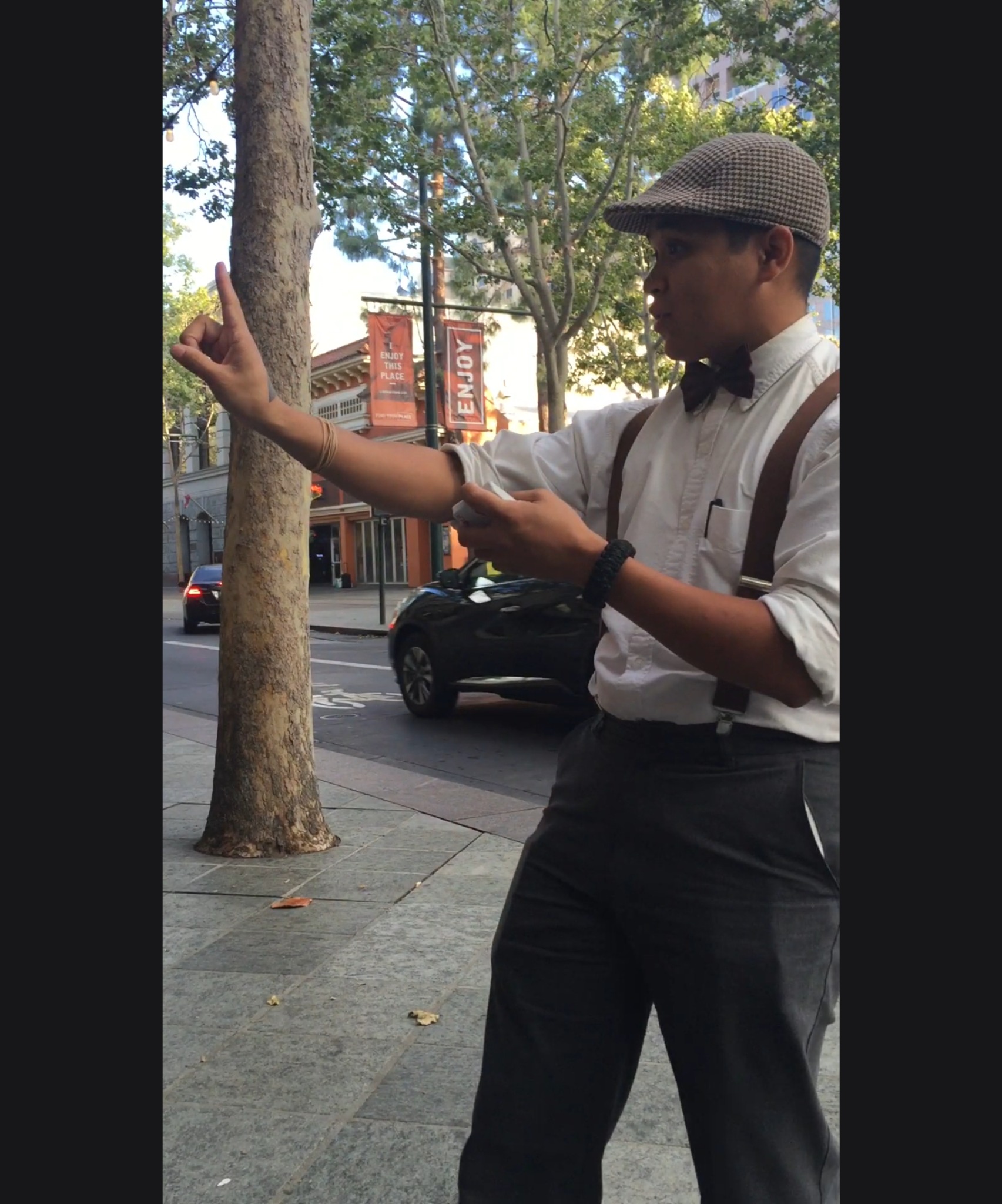 Tetra holding one hand aloft during a street performance